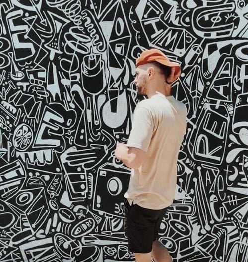 Jake Stringfellow walking in front of mural